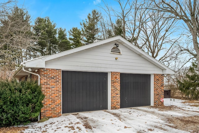 snow covered garage featuring a detached garage