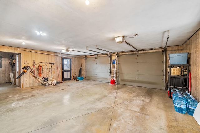 garage with wooden walls and a garage door opener