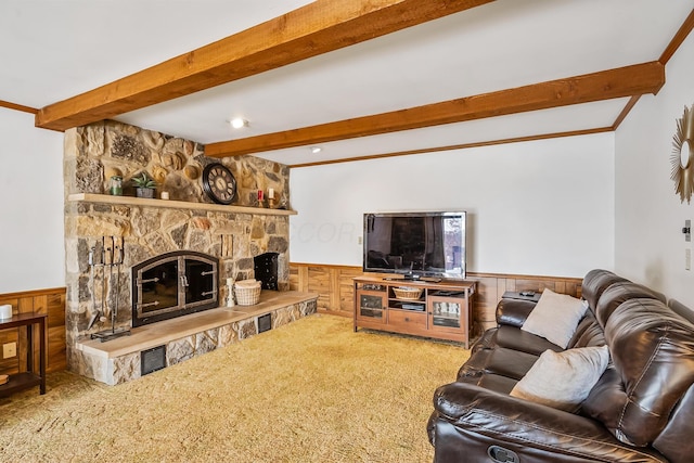 carpeted living room featuring a fireplace, beamed ceiling, and wainscoting