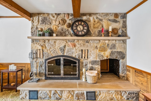 details with wainscoting, beam ceiling, a fireplace, and visible vents