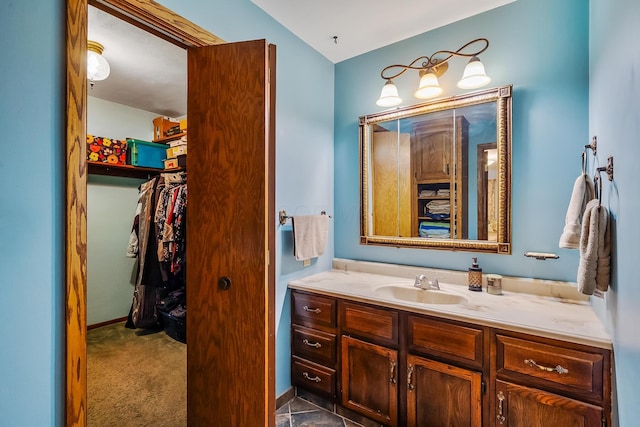 bathroom with a walk in closet and vanity