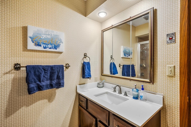 bathroom featuring vanity and wallpapered walls