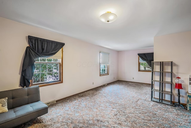 living area featuring carpet flooring, visible vents, and baseboards