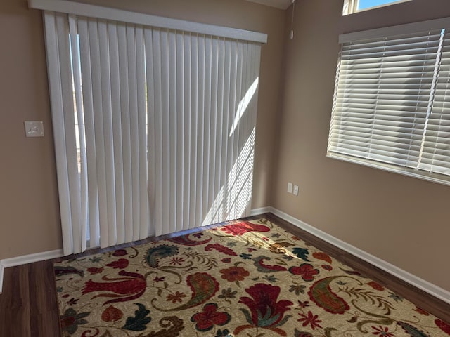 unfurnished room featuring baseboards and wood finished floors