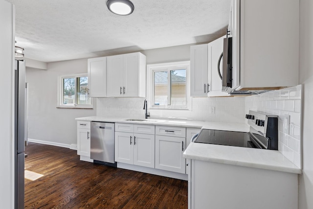 kitchen with white cabinets, a sink, stainless steel appliances, and light countertops