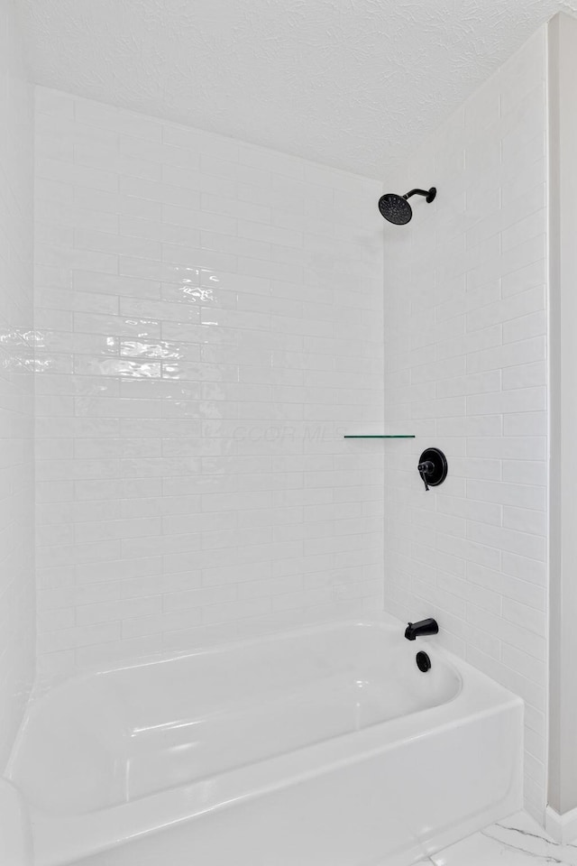 bathroom featuring shower / bath combination and a textured ceiling