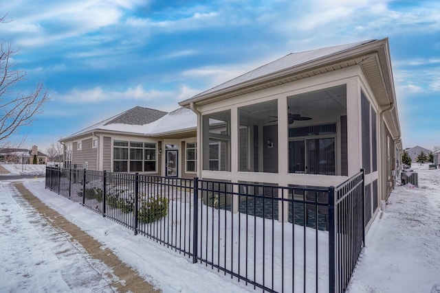 exterior space with a fenced front yard, cooling unit, and a ceiling fan