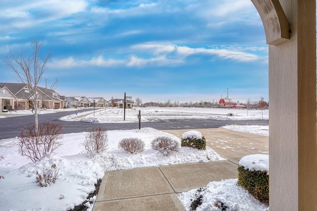 yard covered in snow featuring a residential view