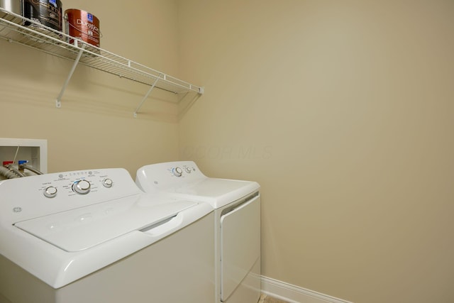 washroom with laundry area, baseboards, and separate washer and dryer