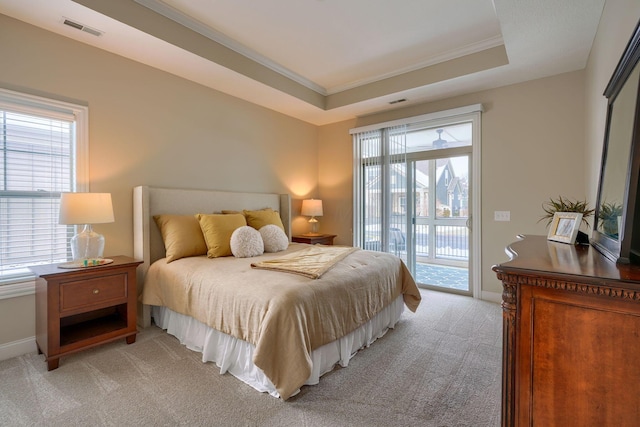 bedroom with baseboards, visible vents, light colored carpet, access to outside, and a tray ceiling