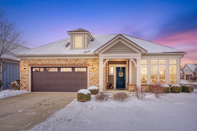 view of front of property with concrete driveway, stone siding, and an attached garage