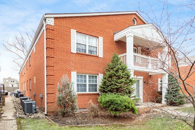 view of side of home featuring brick siding and cooling unit