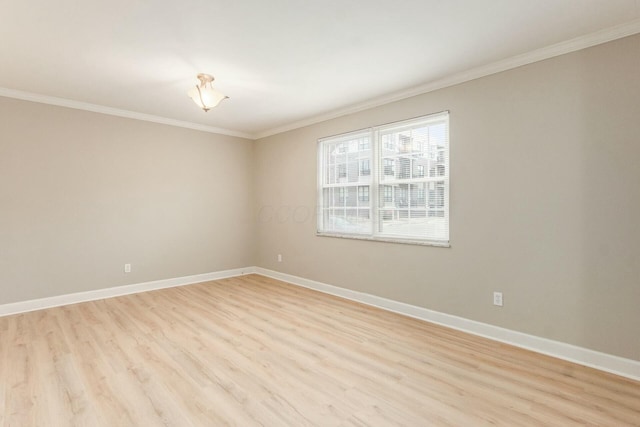 spare room with light wood-type flooring, baseboards, and crown molding