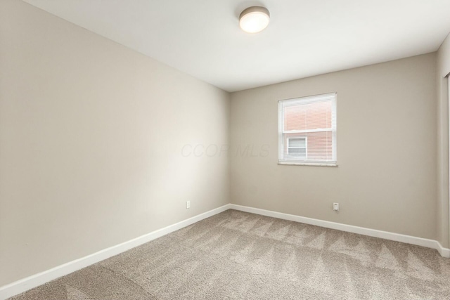 spare room with light colored carpet and baseboards