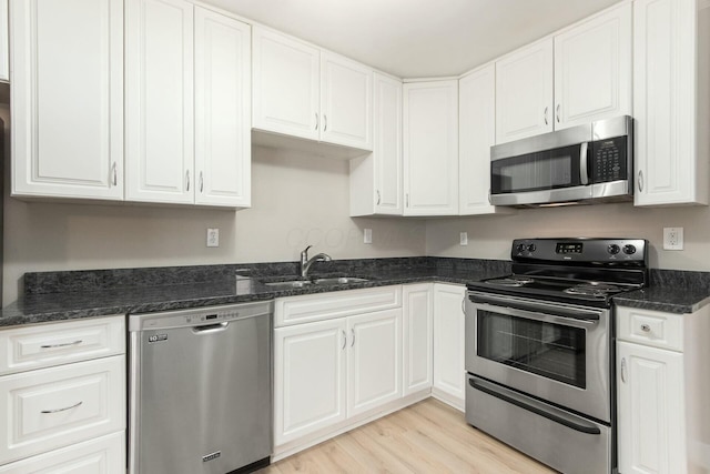 kitchen with a sink, stainless steel appliances, and white cabinets