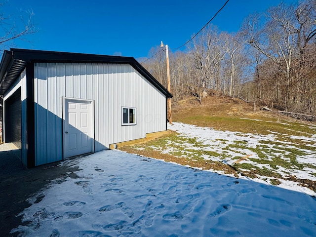 view of snow covered exterior with an outdoor structure