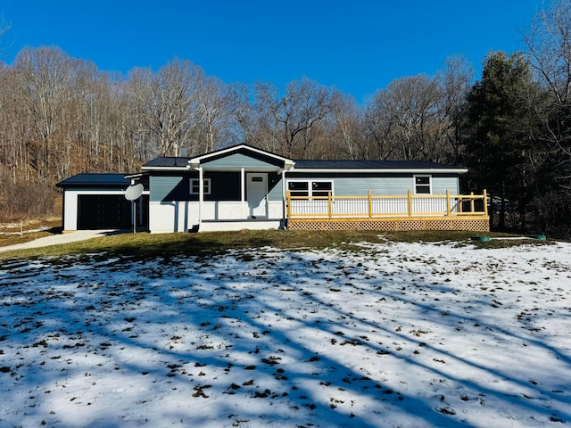 view of front of home featuring a garage, metal roof, and a porch