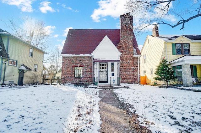 view of front facade featuring brick siding and a chimney