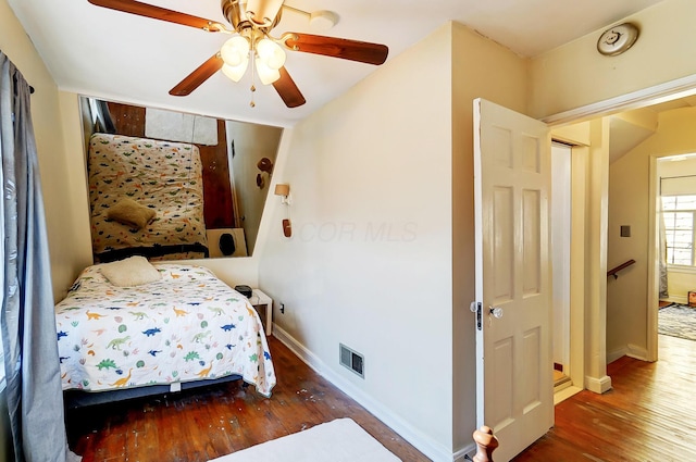 bedroom featuring visible vents, dark wood finished floors, baseboards, and ceiling fan