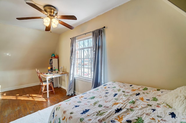 bedroom featuring dark wood-type flooring, lofted ceiling, baseboards, and a ceiling fan