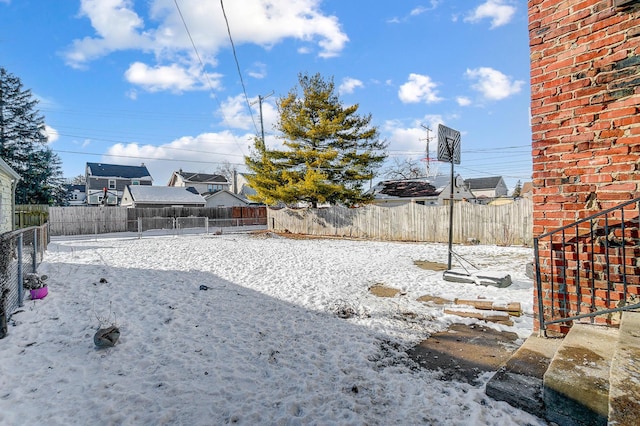 yard layered in snow with a fenced backyard