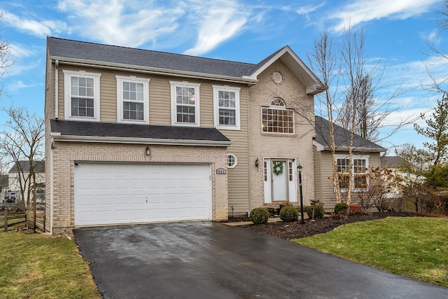 view of front of home with aphalt driveway, a front lawn, an attached garage, and brick siding