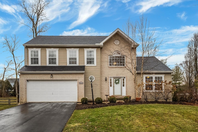 view of front of house featuring a shingled roof, aphalt driveway, an attached garage, a front lawn, and brick siding