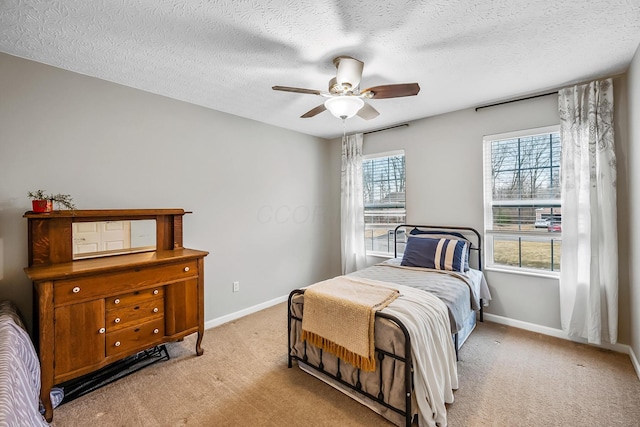 bedroom with light carpet, a textured ceiling, and baseboards