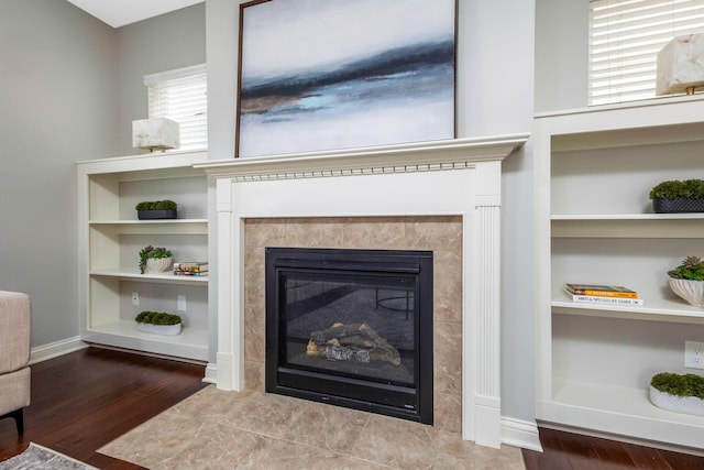 details with built in features, a fireplace, baseboards, and wood finished floors