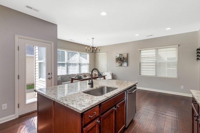 kitchen featuring a sink, visible vents, stainless steel dishwasher, an island with sink, and pendant lighting