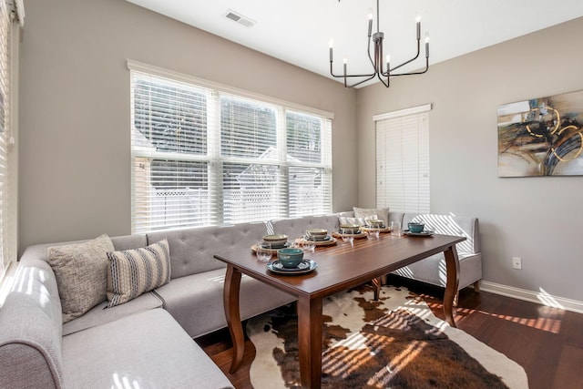 interior space featuring baseboards, visible vents, an inviting chandelier, and wood finished floors