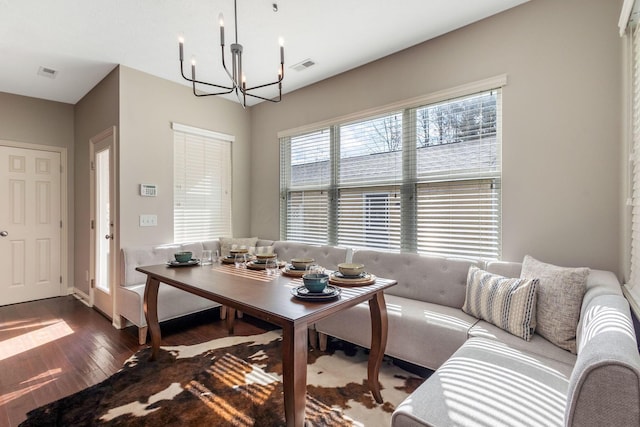 dining area with dark wood-style floors, a chandelier, and visible vents