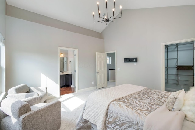 carpeted bedroom with high vaulted ceiling, connected bathroom, baseboards, a spacious closet, and an inviting chandelier