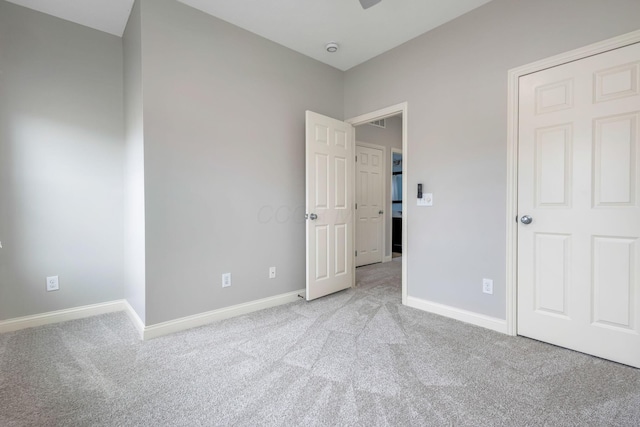 unfurnished bedroom featuring baseboards and light colored carpet