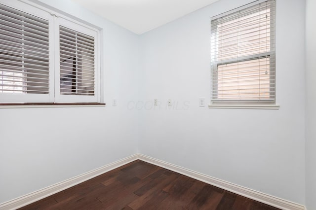 spare room with wood finished floors and baseboards