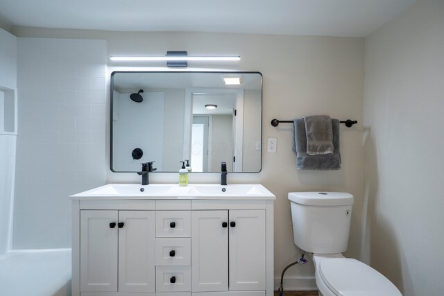 bathroom with a sink, toilet, and double vanity