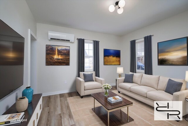 living area featuring a wall mounted AC, baseboards, and wood finished floors