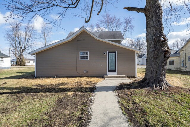 rear view of house featuring a lawn