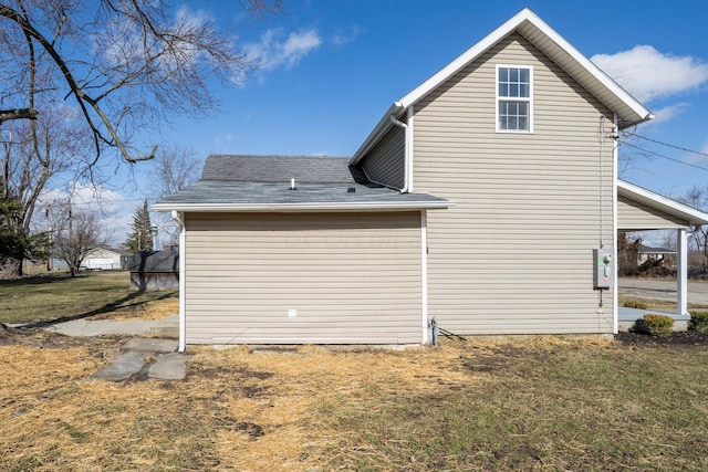 view of property exterior featuring a lawn and roof with shingles