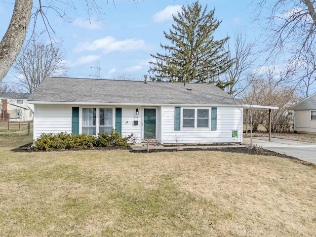 ranch-style house with roof with shingles, concrete driveway, fence, a carport, and a front lawn