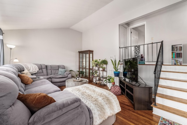 living room featuring stairs, dark wood-type flooring, and lofted ceiling