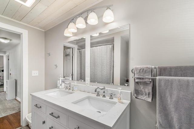 bathroom featuring wood ceiling, double vanity, a sink, and wood finished floors