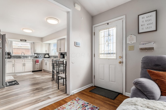 foyer featuring light wood-style flooring and baseboards