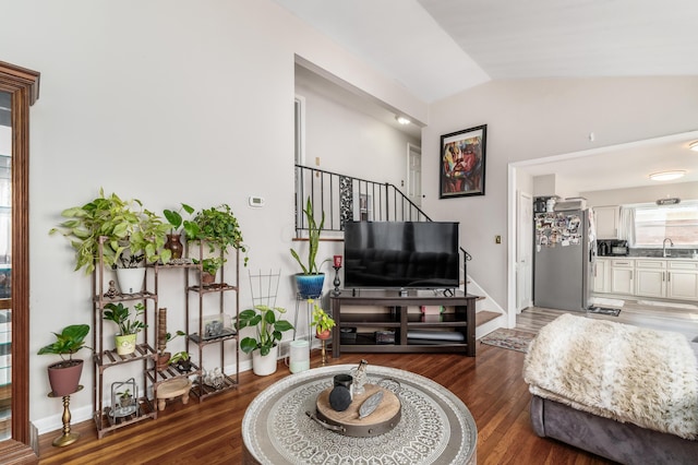 living room featuring dark wood-style floors, vaulted ceiling, stairway, and baseboards