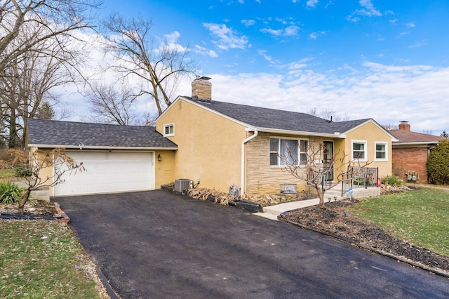 view of front facade with cooling unit, a garage, driveway, stone siding, and a chimney