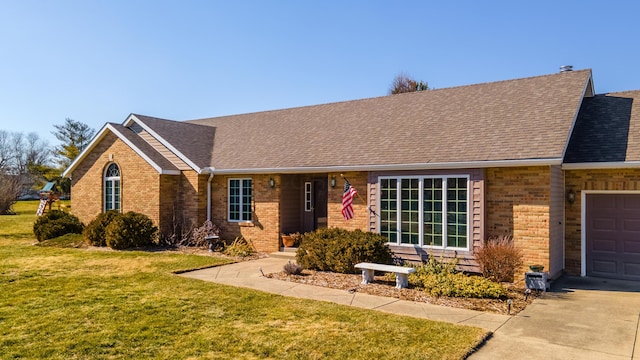 ranch-style home with a shingled roof, a front yard, and brick siding