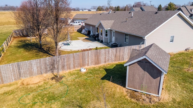 view of yard featuring a fenced backyard, a patio, and central AC unit