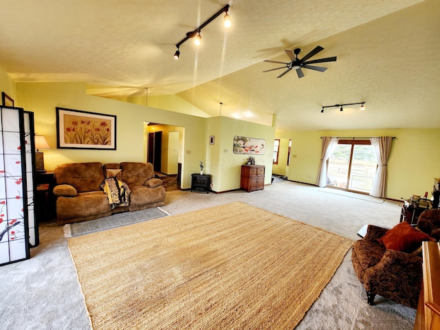 living room featuring lofted ceiling, ceiling fan, a textured ceiling, light carpet, and track lighting