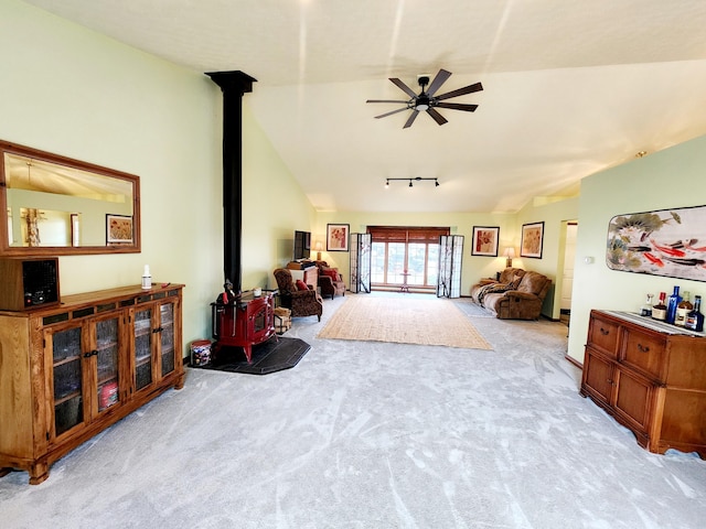 interior space featuring vaulted ceiling, a wood stove, and a ceiling fan