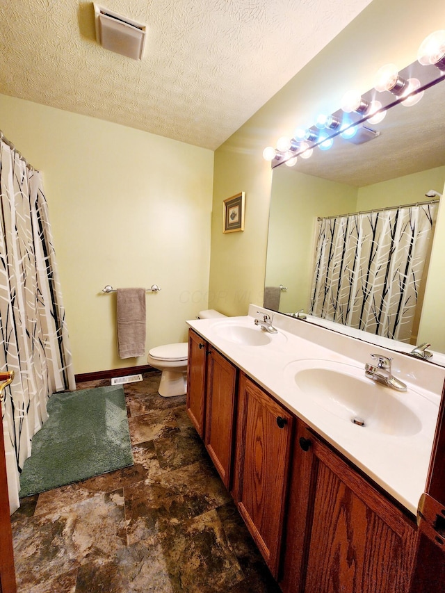 full bath featuring a sink, a textured ceiling, and toilet